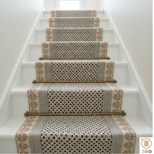 May include: Staircase with white risers and patterned stair runners. The runners feature a repeating geometric design in shades of brown and beige, with decorative borders and brass rods.