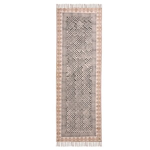 Puede incluir: Alfombra rectangular estampada, con fondo crema y dise&ntilde;o geom&eacute;trico repetido en blanco y negro. Borde gris y borde decorativo marr&oacute;n, con flecos en los extremos. Ideal para pasillo o entrada, con unos 200 cm de largo.