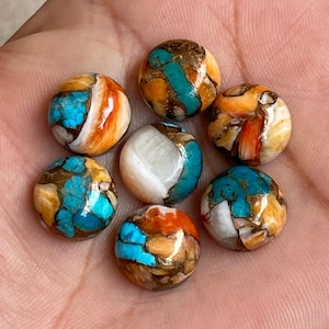 Könnte beinhalten: Sieben runde Cabochon-Edelsteinkugeln mit einer Mischung aus Türkis, Braun, Orange und Weiß. Die Kugeln sind glatt und poliert.