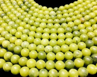 May include: A strand of round, light green jade beads. The beads are smooth and polished, and they are arranged in a symmetrical pattern.