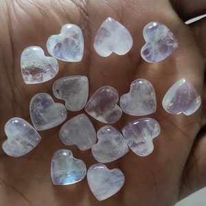 May include: A collection of 12 white heart-shaped moonstone crystals. The crystals are translucent and have a slight iridescent sheen.