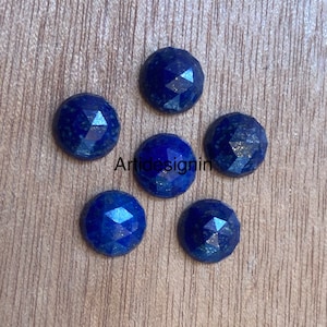 May include: Six round, faceted, dark blue lapis lazuli cabochons. The stones have a sparkly, glittery appearance.
