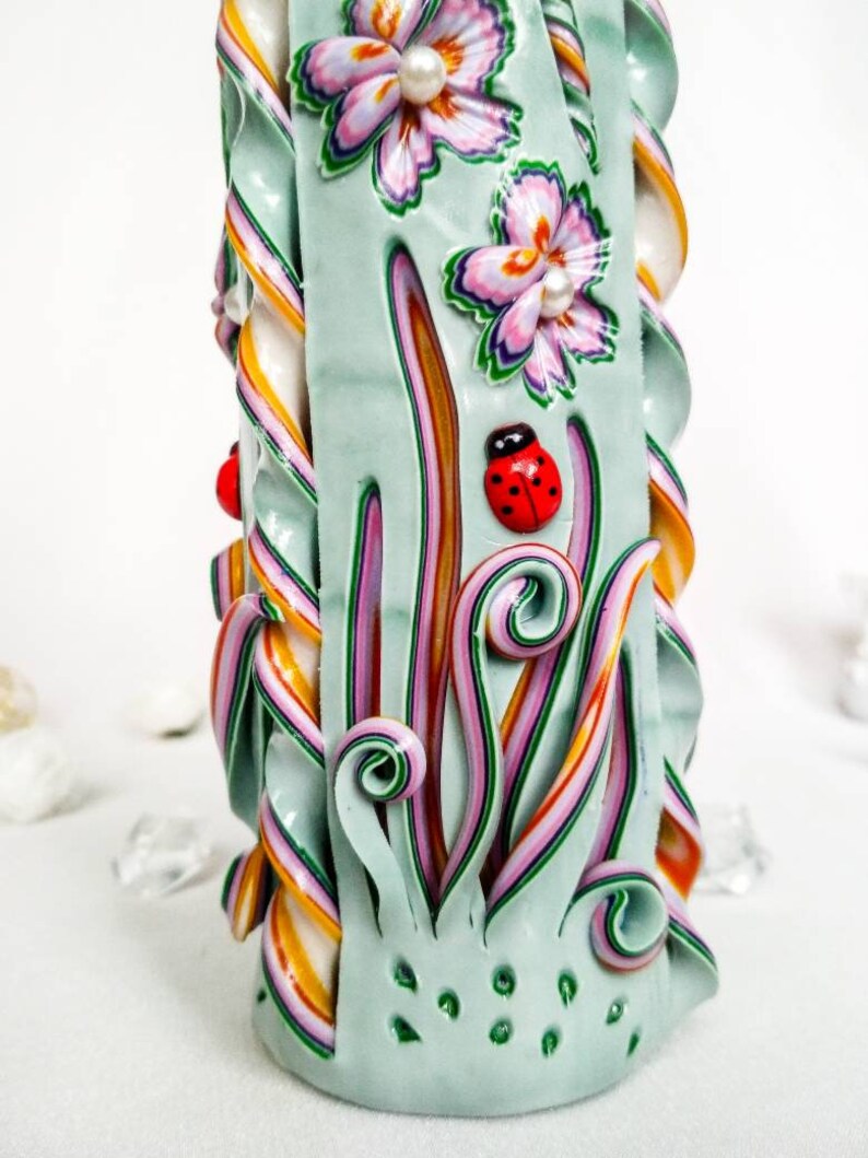 Green carved candle with flowers and butterflies is the Etsy