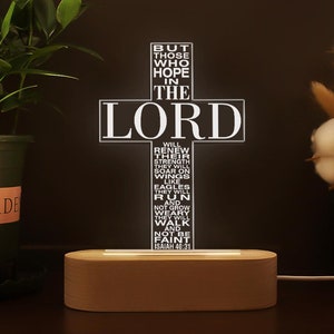 May include: A wooden base with a white cross-shaped light that displays the text "But those who hope in the Lord will renew their strength. They will soar on wings like eagles. They will run and not grow weary. They will walk and not be faint. Isaiah 40:31"