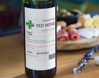 Puede incluir: Una botella de vino tinto con una etiqueta de prescripción humorística que dice "PRESCRIPTION RED WINE" con una instrucción de dosificación para "tomar dos veces al día".