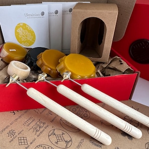 Può includere: Un kit per decorare uova contenente tre kistka con manici in legno e punte in metallo, diversi dischi rotondi di cera d'api gialli e neri, una piccola scatola di cartone marrone e schede di istruzioni con scritto Ukrainian Eggcessories.