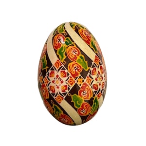 May include: A hand-painted Easter egg with a geometric pattern in shades of brown, white, red, orange, and green.