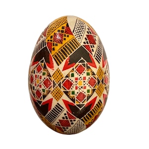 May include: A hand-painted Easter egg with a geometric pattern in red, yellow, black, and green.