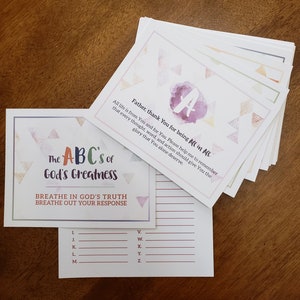 Può includere: Un set di carte stampabili con uno sfondo ad acquerello e un motivo a triangoli. Le carte presentano l'alfabeto e la frase "The ABC's of God's Greatness". Il testo "Breathe in God's Truth, Breathe out your response" è incluso.