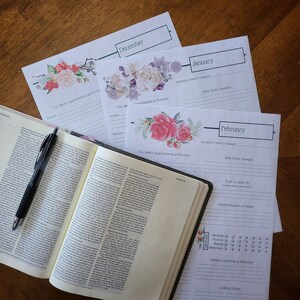 May include: A set of printable monthly planner pages with floral illustrations. Each page includes sections for Scripture memory passages, Bible study passages, appointments and priorities, prayer requests and praises, and a weekly gratitude and reflection section.