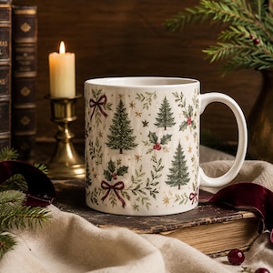 Elegant vintage Christmas mug with evergreen trees, holly berries, burgundy bows and antique gold stars, styled with linen, old books, candlelight, evergreen branches and velvet ribbon in a warm holiday setting.