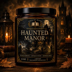 Haunted Manor luxury soy candle in an amber glass jar with an illustrated Victorian manor label, candlelit windows, wrought iron gates, and elegant gothic Halloween artwork by Tale of Wicks.