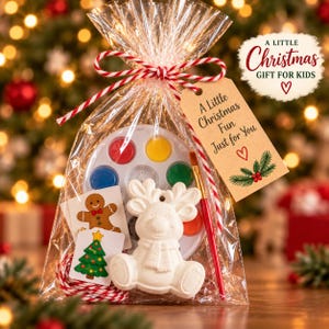 Puede incluir: Una bolsa de regalo de plástico transparente que contiene una figura de reno de cerámica blanca, una paleta de pintura circular con seis colores, un pincel y dos tarjetas pequeñas con un hombre de jengibre y un árbol de Navidad. Incluye una etiqueta.