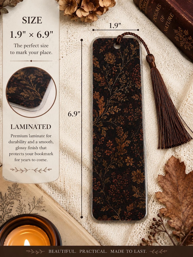 Moody autumn botanical laminated bookmark with brown tassel shown with 1.9 by 6.9 inch dimensions and close-up of the protective laminate finish, styled with fall leaves, vintage books and warm candlelight.