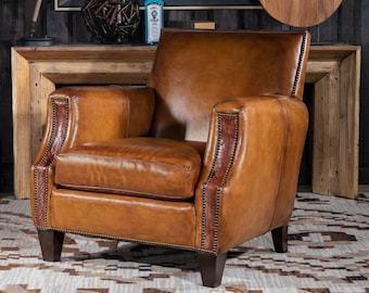 May include: A brown leather armchair with a tufted back and arms. The chair has a distressed look and is accented with nailhead trim. The chair is sitting on a rug with a geometric pattern.