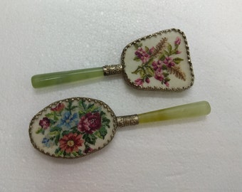 Puede incluir: Dos espejos de mano antiguos con bordado floral en la parte delantera. Los espejos tienen mangos de color verde jade con detalles plateados.