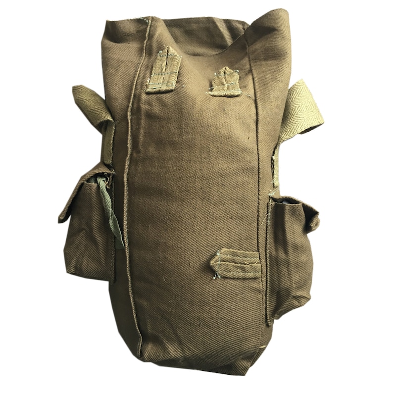 Pu&ograve; includere: Una borsa per maschera antigas in tela marrone con due tasche laterali e una tracolla. La borsa &egrave; in tessuto strutturato ed &egrave; progettata per trasportare una maschera antigas.