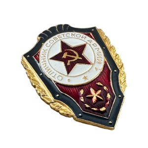May include: A gold-colored metal badge with a red and white star and the text "ОТЛИЧНИК СОВЕТСКОЙ АРМИИ" in a black circle.