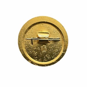 Puede incluir: La parte posterior de un pin redondo de color dorado con un cierre de pin y una peque&ntilde;a inscripci&oacute;n.