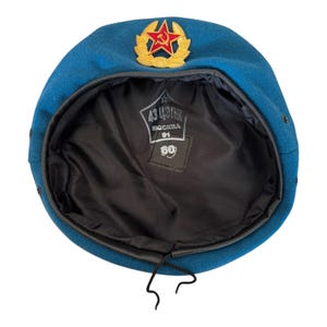 May include: Blue beret with a red star and gold laurel wreath emblem. The inside of the beret has a black lining and a label that reads "43 ЦЕХ  МОСКВА 91 60".