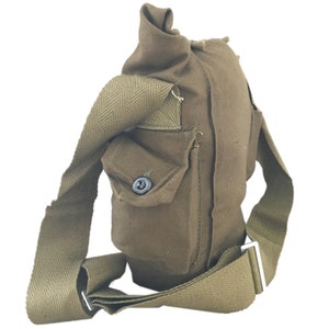 Pu&ograve; includere: Un porta borraccia in tela marrone con una tracolla e una piccola tasca sul davanti. Il porta borraccia ha una chiusura a bottone sulla tasca.