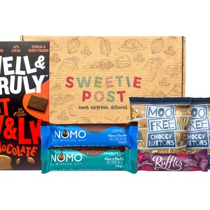May include: A brown cardboard box with the words "Sweetie Post" printed on it. The box contains a variety of chocolate bars and snacks, including Well & Truly Oat M&L Chocolate, Moo Free Choccy Buttons, and NomO Vegan & Free From Chocolate Bars.