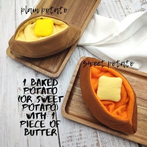 Puede incluir: Dos patatas asadas de fieltro, una normal y una batata, cada una con un trozo de mantequilla encima. El texto "1 BAKED POTATO (OR SWEET POTATO) WITH 1 PIECE OF BUTTER" est&aacute; escrito debajo de las patatas.