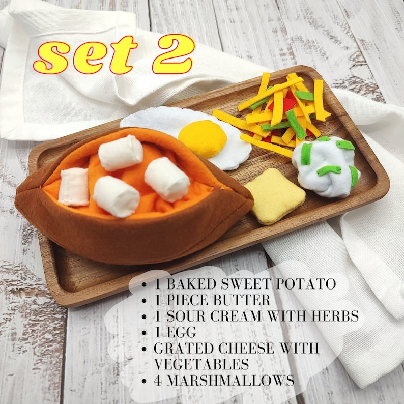 Puede incluir: Un conjunto de alimentos de fieltro en una bandeja de madera, que incluye una batata horneada con malvaviscos, una pieza de mantequilla, crema agria con hierbas, un huevo, queso rallado con verduras y una pieza de pan. El texto "set 2" est&aacute; escrito en amarillo sobre un pa&ntilde;o blanco en el fondo.