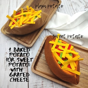 Puede incluir: Dos patatas asadas de fieltro, una normal y otra dulce, ambas cubiertas con queso rallado. El texto "1 BAKED POTATO (OR SWEET POTATO) WITH GRATED CHEESE" est&aacute; escrito debajo de las patatas.