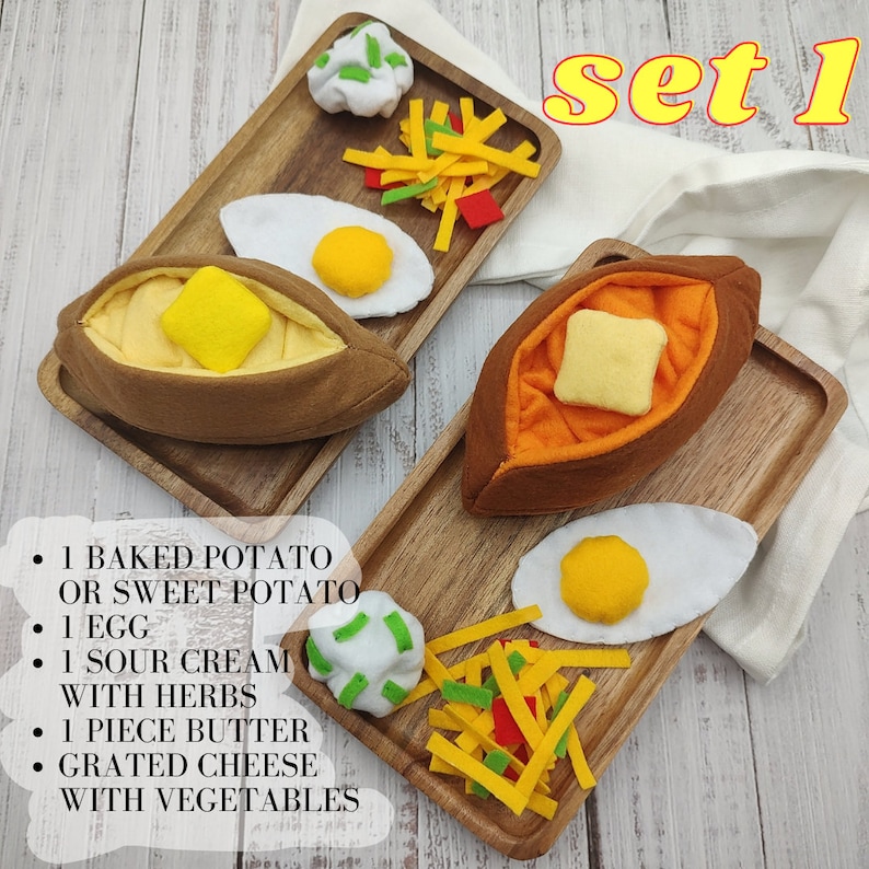 Puede incluir: Conjunto 1 de un juego de comida de fieltro que incluye una patata al horno o una batata, un huevo, crema agria con hierbas, un trozo de mantequilla, queso rallado y verduras. La comida est&aacute; dispuesta en dos bandejas de madera.