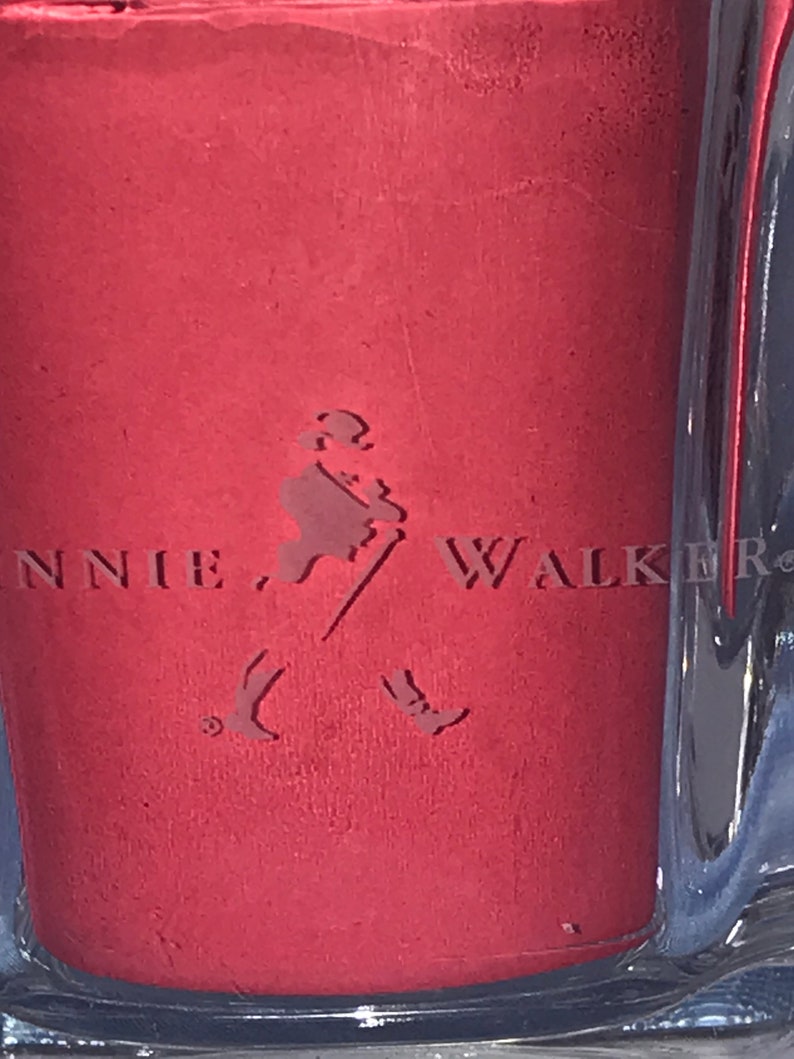 May include: A red bottle with a label that says "Johnnie Walker" and features a walking man logo.