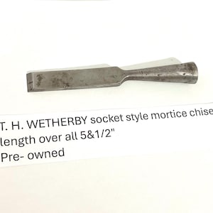 May include: A vintage T.H. Wetherby socket style mortice chisel. The metal tool is 5.5 inches long and has a rectangular blade and a tapered handle. The chisel is pre-owned.