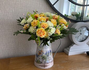 Arreglo floral artificial de claveles con follaje verde en una jarra de hojalata vintage. Arreglo floral de seda sintética estilo campestre.