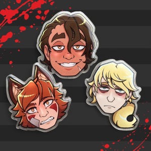 May include: Three cartoon character face pins with a glossy finish. The faces are of a man with brown hair, a fox-like character with red hair, and a blonde-haired character. The background is dark gray with red splatters.