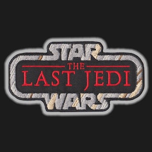 Może przedstawiać: Naszywka haftowana w kolorze szarym i białym z napisem "Star Wars The Last Jedi" w czerwonych i czarnych literach.