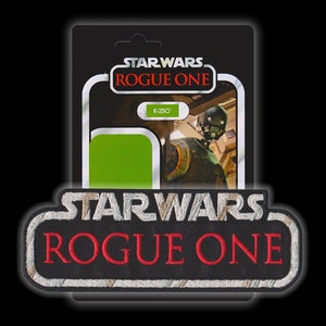 Può includere: Una toppa ricamata in bianco e nero con il testo "STAR WARS ROGUE ONE" in lettere bianche e rosse. La toppa è circondata da un bordo nero.
