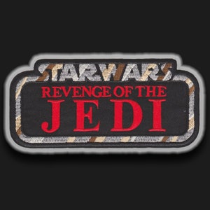 以下が含まれることがあります： 黒と白の刺繍パッチで、赤い文字と白い文字で「STAR WARS REVENGE OF THE JEDI」と書かれています。