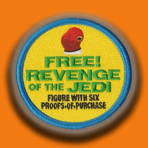 May include: A yellow and blue circular patch with the text "FREE! REVENGE OF THE JEDI" in green and black lettering. The patch also features a red and white figure with a white collar and a red head. The text "FIGURE WITH SIX PROOFS-OF-PURCHASE" is printed in black below the figure.