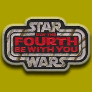 May include: A black and white embroidered patch with the text "Star Wars" in white, "May the Fourth Be With You" in red, and a striped background.