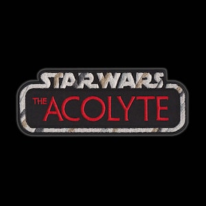 May include: A black and white embroidered patch with the text "STAR WARS THE ACOLYTE" in red.