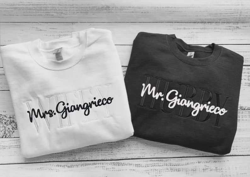 May include: Two white and black sweatshirts with the text "Mrs. Giagrieco" and "Mr. Giagrieco" embroidered on them.