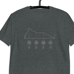 May include: Dark gray t-shirt with a graphic of an ADSR envelope and knobs. The design features a stylized waveform and the letters A, D, S, and R below the knobs. The shirt is hanging on a black hanger.