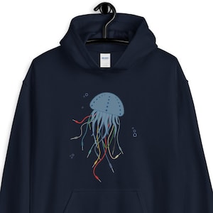 Puede incluir: Una sudadera con capucha azul marino con un gráfico de una medusa azul con cables coloridos para tentáculos.