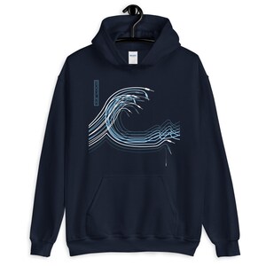 Puede incluir: Una sudadera con capucha azul marino con un gráfico blanco de una ola hecha de líneas y la palabra "COOL WAVE" en una columna vertical en el lado izquierdo del gráfico.