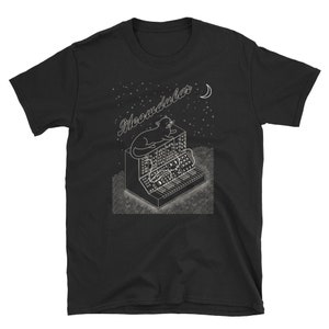 Könnte beinhalten: Schwarzes T-Shirt mit einem weißen Grafikdruck eines Katers, der auf einem Synthesizer sitzt, mit dem Text "Meowdular" darüber. Die Grafik enthält auch einen Halbmond und Sterne.