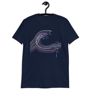 Puede incluir: Una camiseta azul marino con un diseño de ola abstracta de colores. La ola está formada por múltiples líneas en tonos de azul, rosa, amarillo y verde.