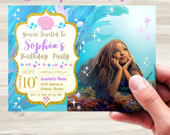 May include: A blue and purple mermaid-themed birthday party invitation with gold glitter accents. The invitation features a photo of a young girl with long brown hair, a seashell, and the text "You're Invited to Sophia's Birthday Party". The invitation also includes the date, time, and location of the party.