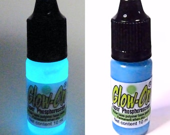 May include: Two bottles of blue glow-in-the-dark paint. The bottle on the left is glowing under a black light. The bottle on the right is in natural light. Both bottles are labeled "Glow-On Super Phosphorescent Water base polymer base paint Permanent when dry Net content 10 ml."