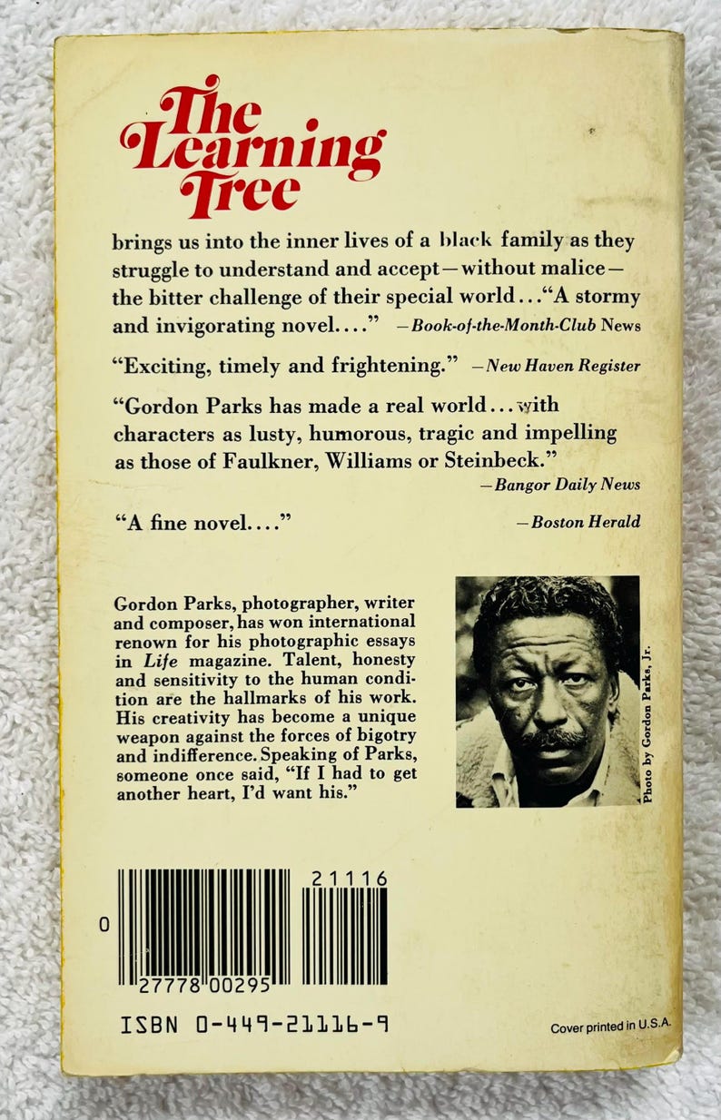 Pu&ograve; includere: La copertina del libro "The Learning Tree" presenta un titolo rosso e una foto in bianco e nero di un uomo. La copertina include citazioni e una breve biografia dell'autore, Gordon Parks.
