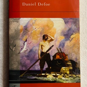 May include: A hardcover copy of "Robinson Crusoe" by Daniel Defoe. The cover features an illustration of a man on a raft, with seagulls in the sky. The book is part of the Barnes & Noble Classics series.